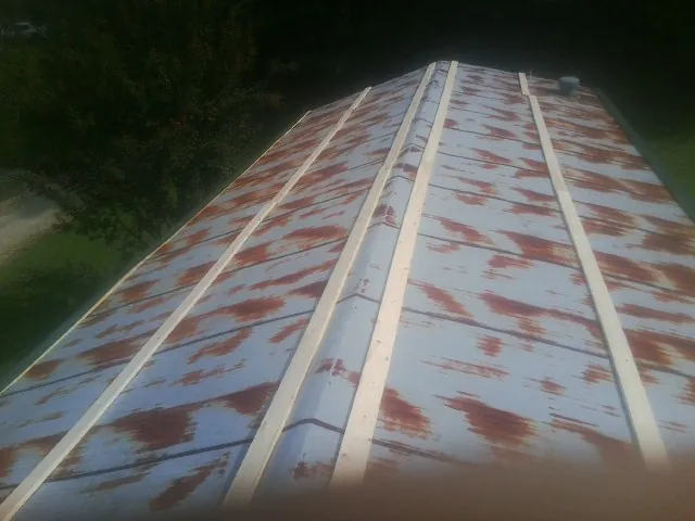 Rusted metal roof panels with new wood purlins before replacement — Storm Damage Roof Repair in Transfer by Roofing Brothers